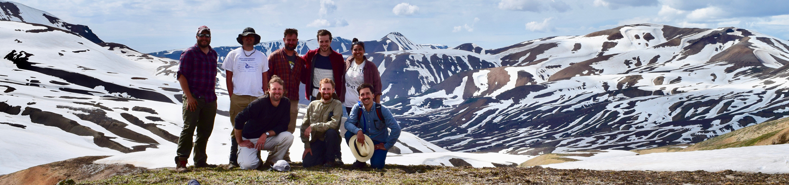 A group of people smile in front of a mountain view.